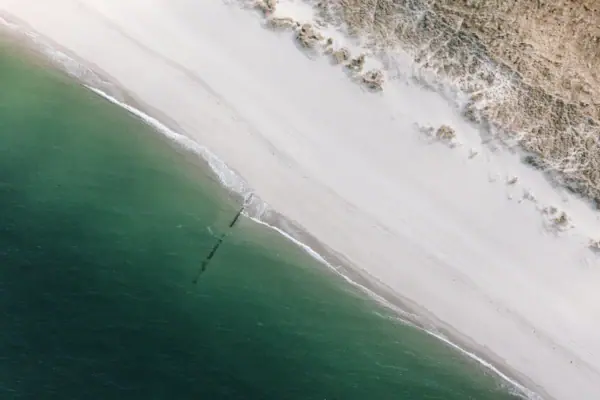 A beautiful beach on Sylt, with sand and water, seen from a bird’s-eye view.