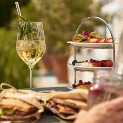 A plate of food with a wine glass on a table.