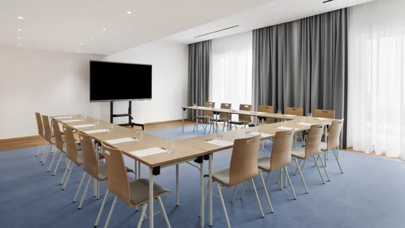Meeting and Conference Room, Tegernsee The A-ROSA Tegernsee, a conference hotel with a conference room featuring a few tables and chairs.