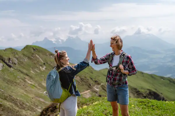 Teamwork Zwei Frauen geben sich im Freien ein High Five.