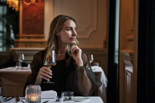 Woman enjoying fine dining at Straubinger Grand Hotel during Christmas in Salzburger Land.
