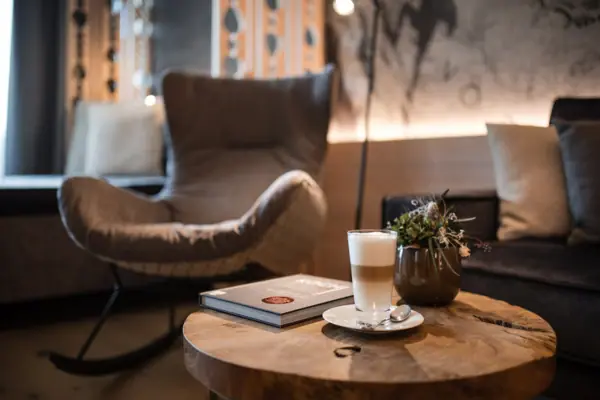 A table with a book and a glass of liquid on it.