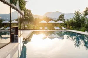 Ein Pool mit Liegestühlen und Sonnenschirmen vor einem Haus.