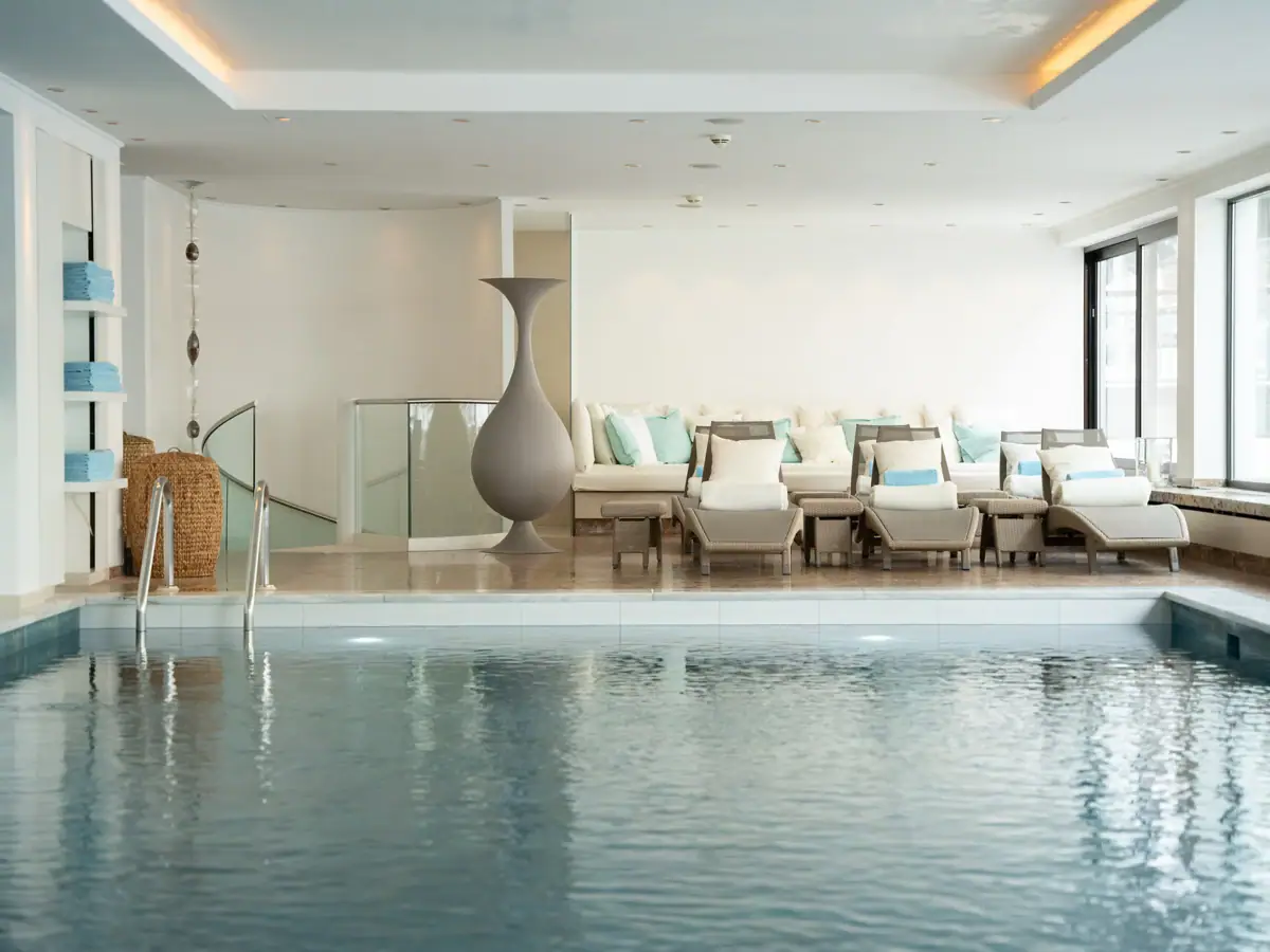 Ein Pool mit einem großen Vase und Stühlen.