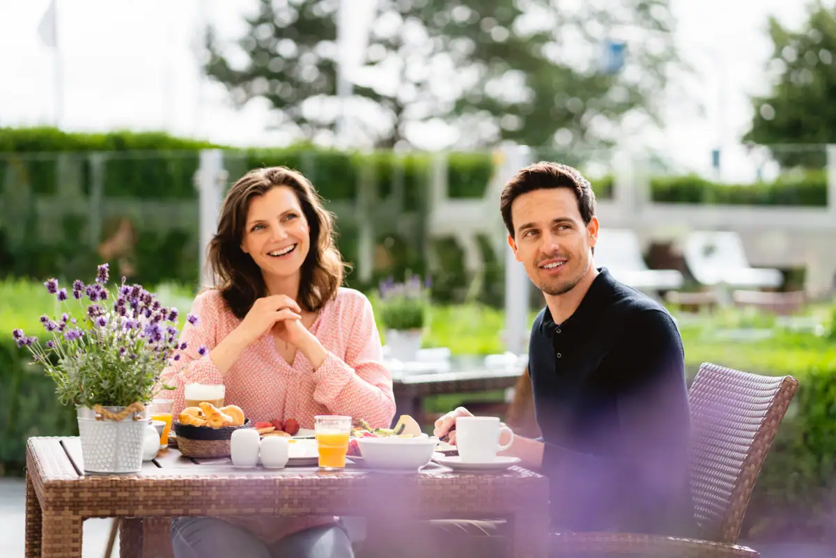 Ein Mann und eine Frau sitzen an einem Tisch mit Essen.
