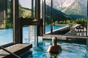 A woman in a swimming pool with mountains in the background.