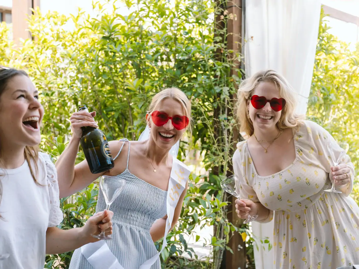 Prosecco-Party auf der Terrasse am Gardasee Freundinnen lachen und feiern mit Prosecco bei einer Bachelorette-Party am Gardasee