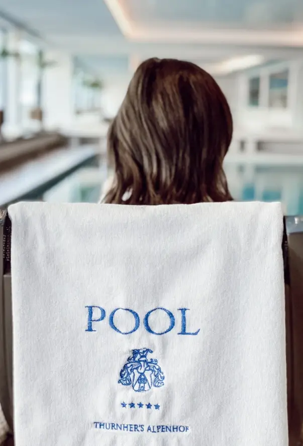 Person sitting in a chair with a towel on the back.