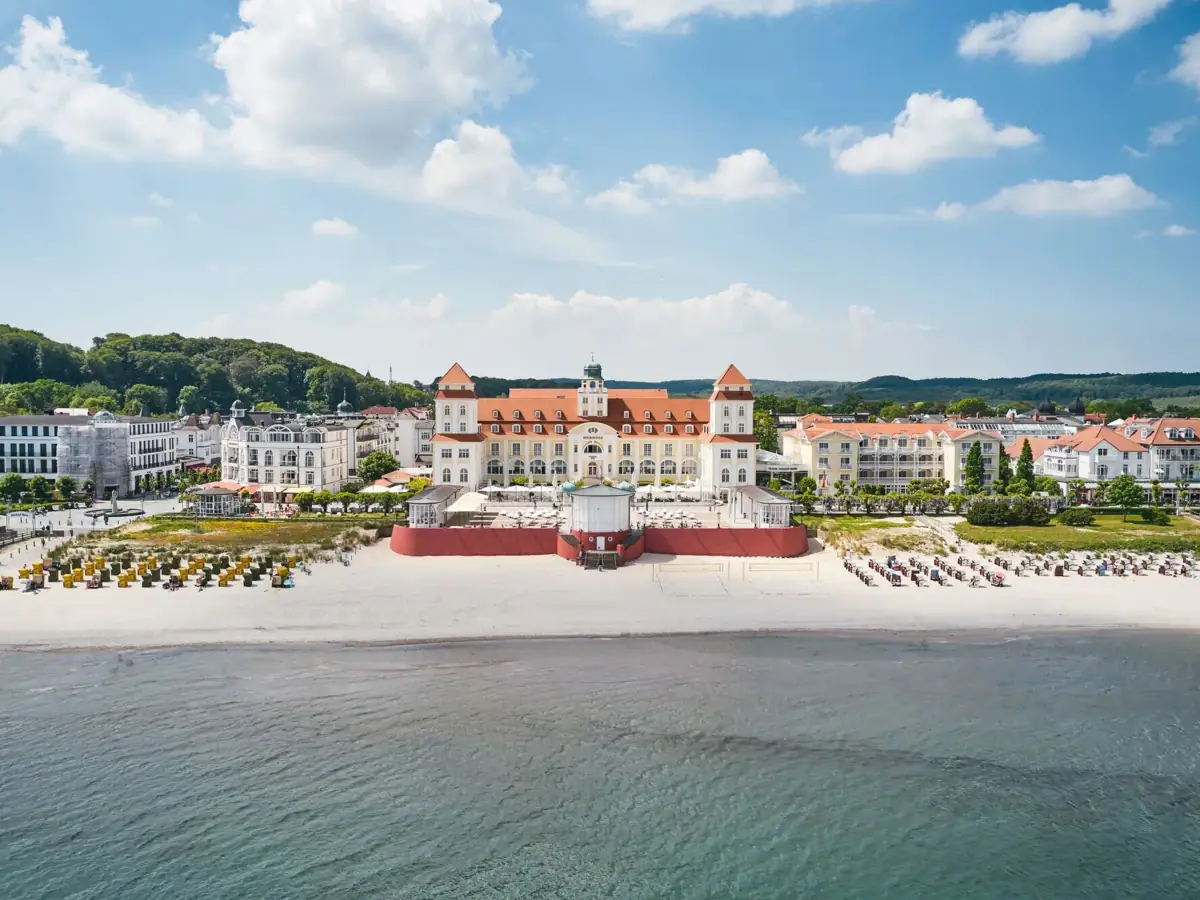 Kurhaus Binz Das Kurhaus Binz mit Glockenturm und Strand im Vordergrund.