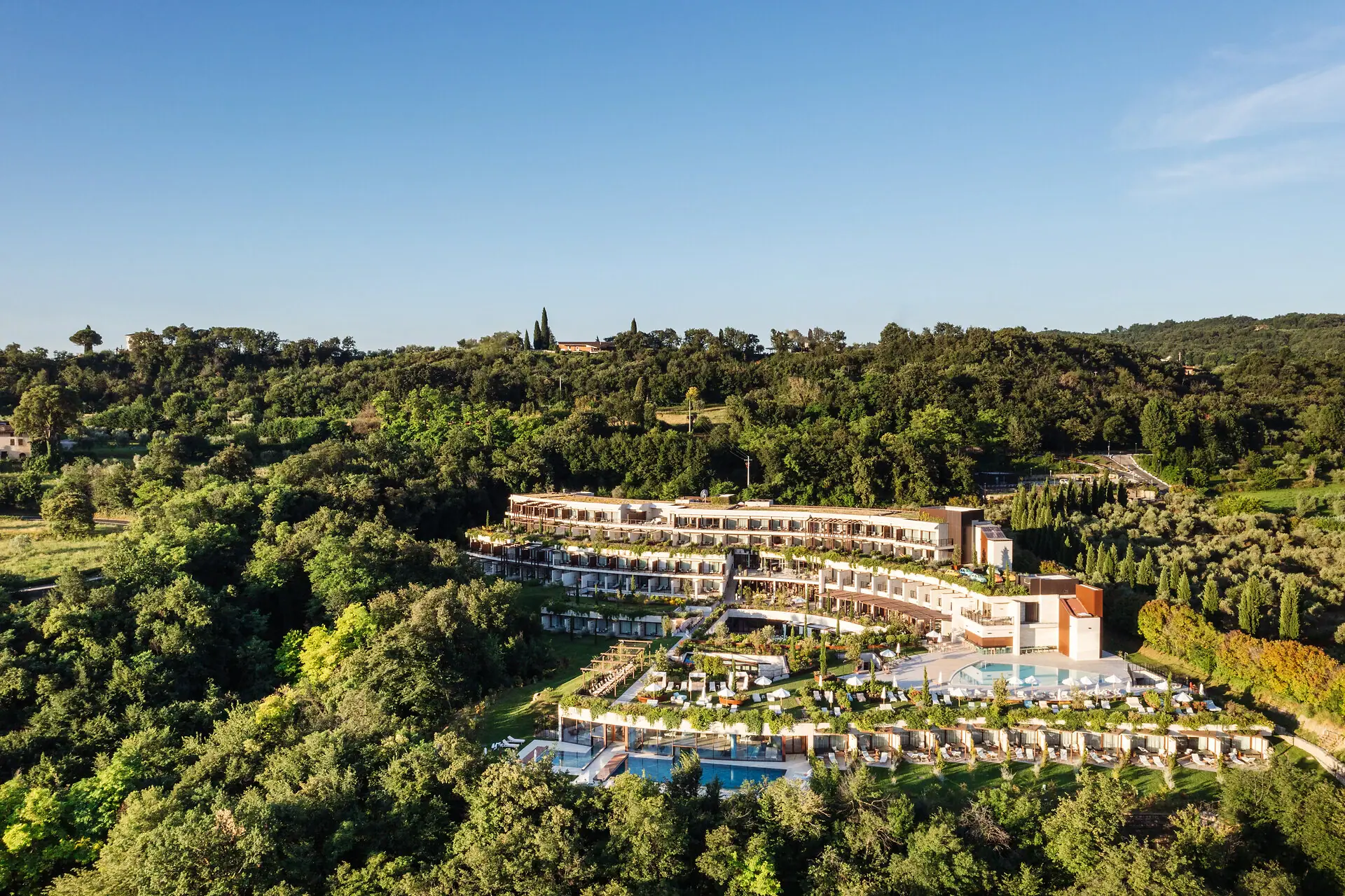 A building with a pool surrounded by trees.