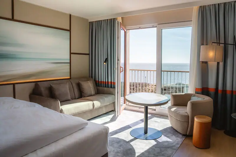 Hotel room with bed, table and chairs.