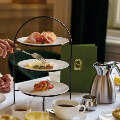 A person holding a fork over plates of food.