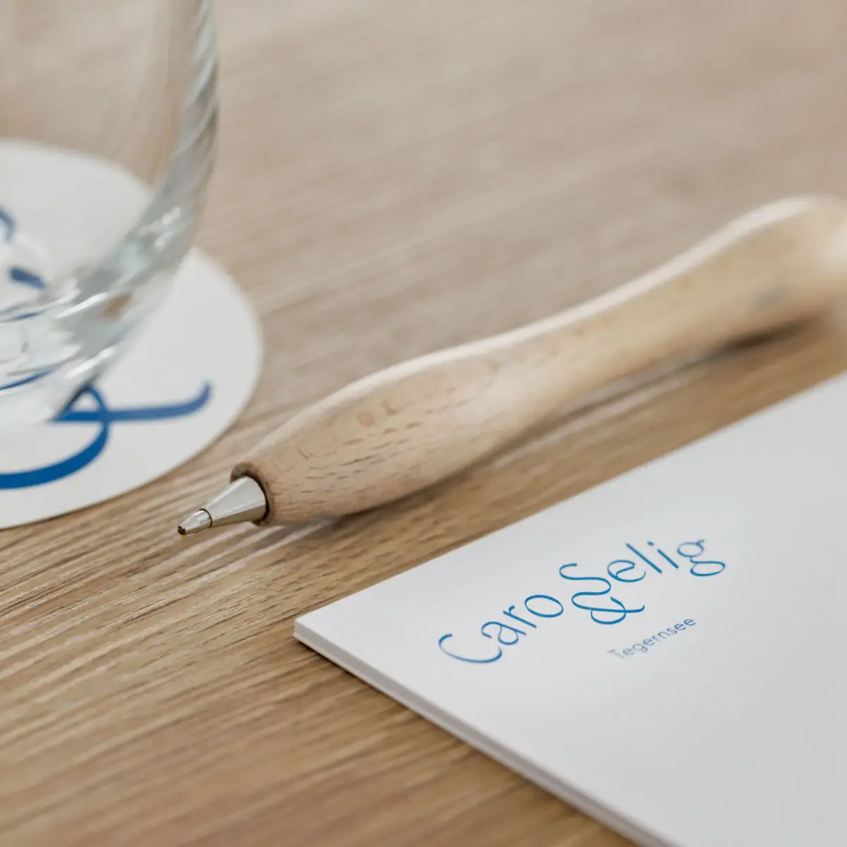 On a table at a conference, there is a notepad and a pen.