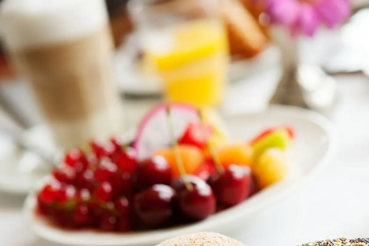 Breakfast moments A plate of food and fruit on a table.