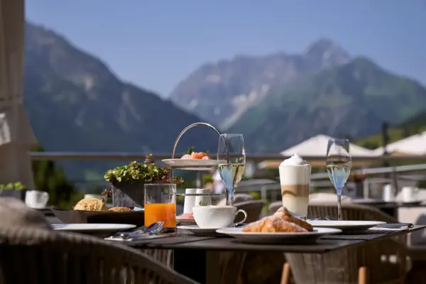 A table with food and drinks against the backdrop of Hallstatt.