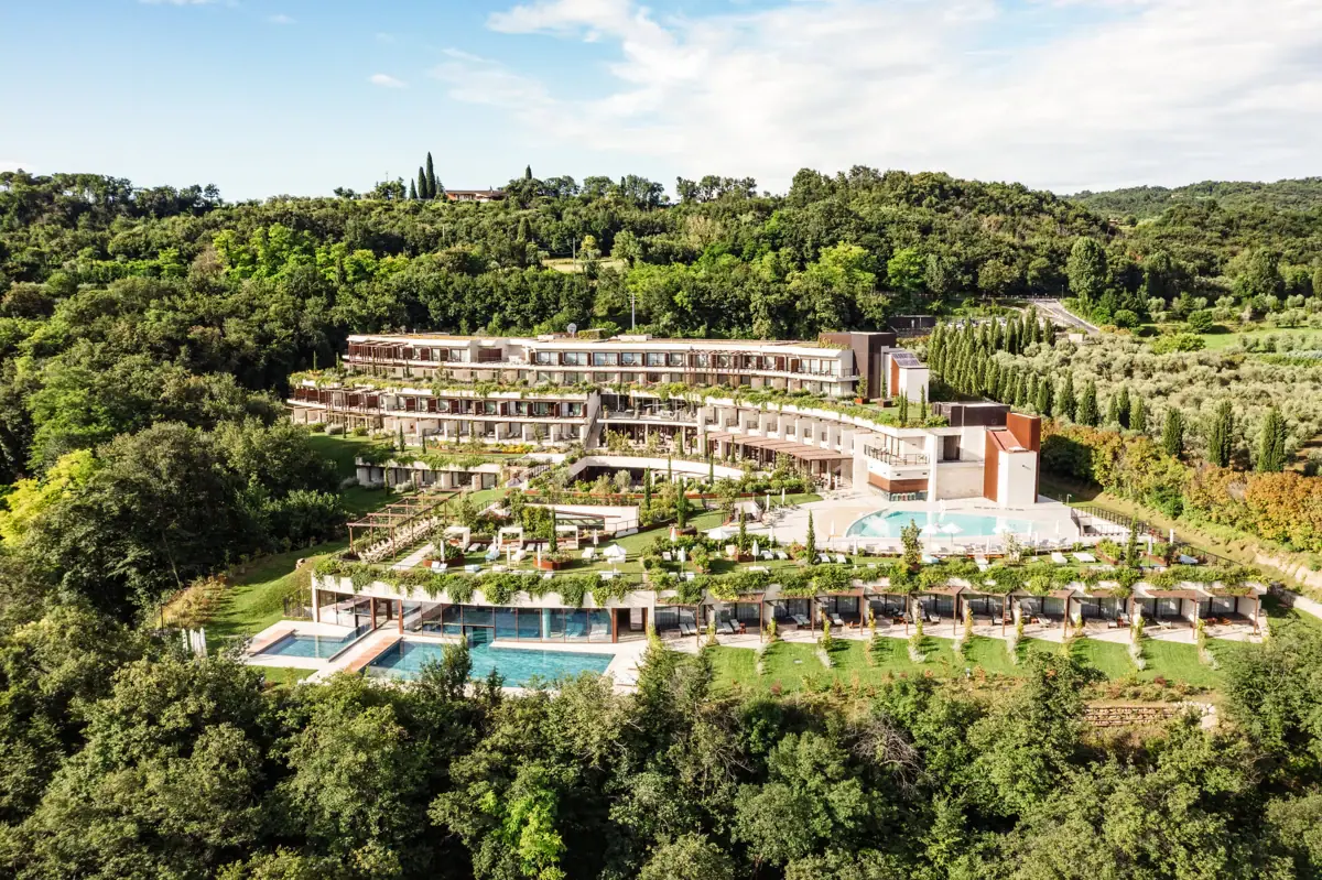 A-ROSA Hotel on Lake Garda A building with a swimming pool, surrounded by trees.
