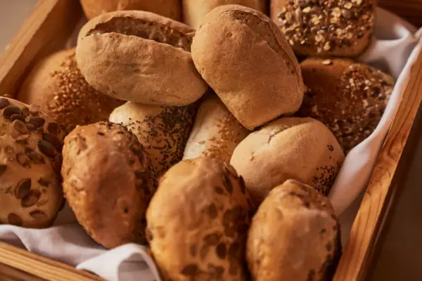 A basket of assorted bread in a wooden box.
