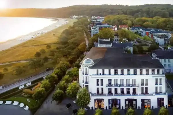A building next to a lake with trees and a clear sky.