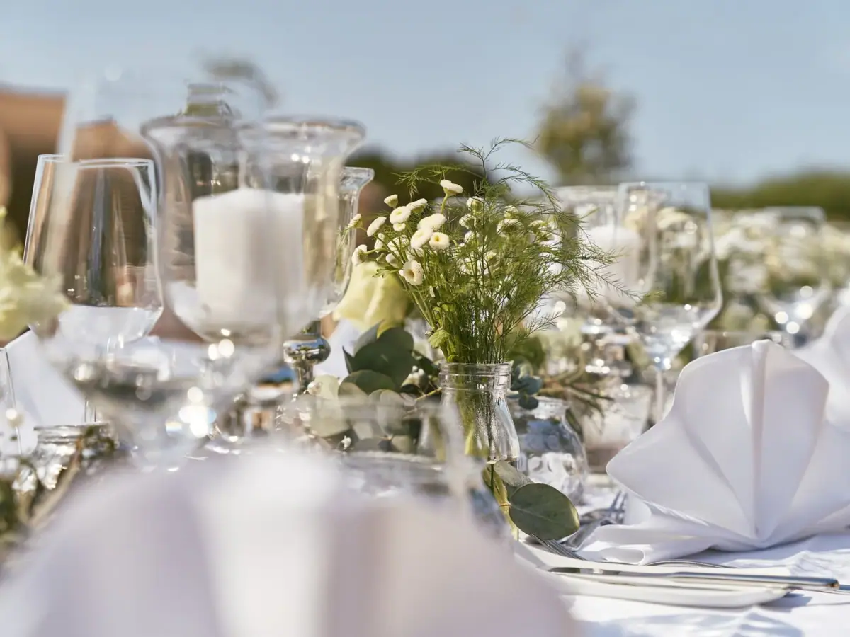 A table set with glasses and a floral centerpiece.