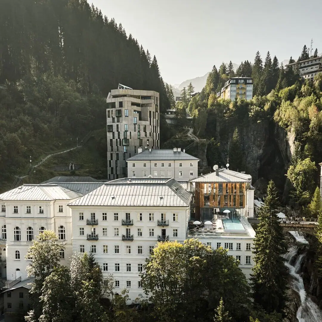 A group of buildings with trees and mountains in the background.