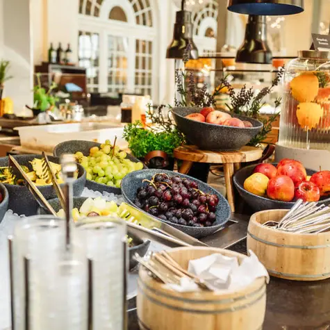 A table with bowls of fruit and cutlery.