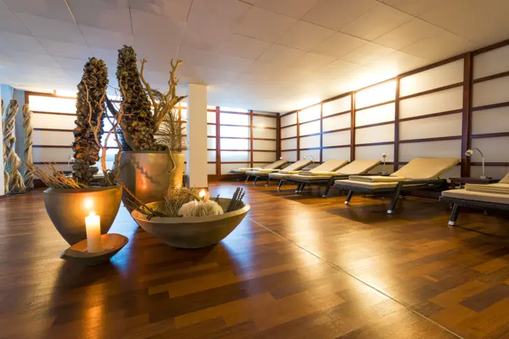 Interior with deckchairs at the edge and maritime decorations and a candle in the middle of the room.