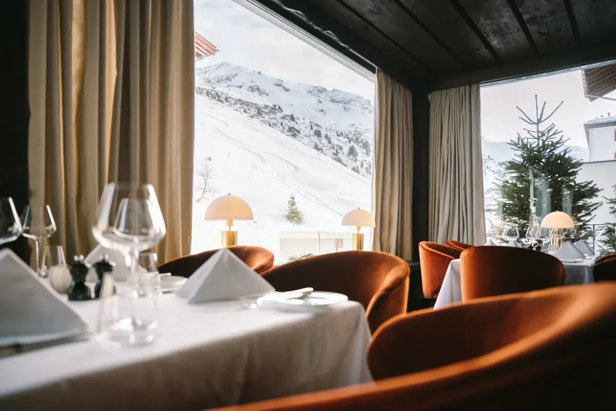 Ein Restaurant mit Blick auf die Berge durch große Fenster.