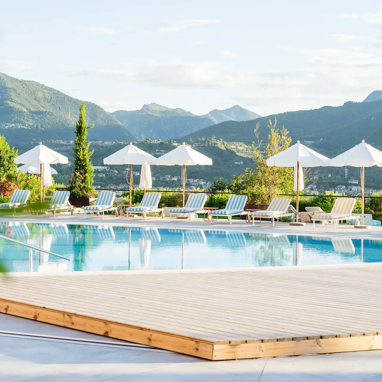 A-ROSA Lake Garda An outdoor pool with sun loungers and parasols.