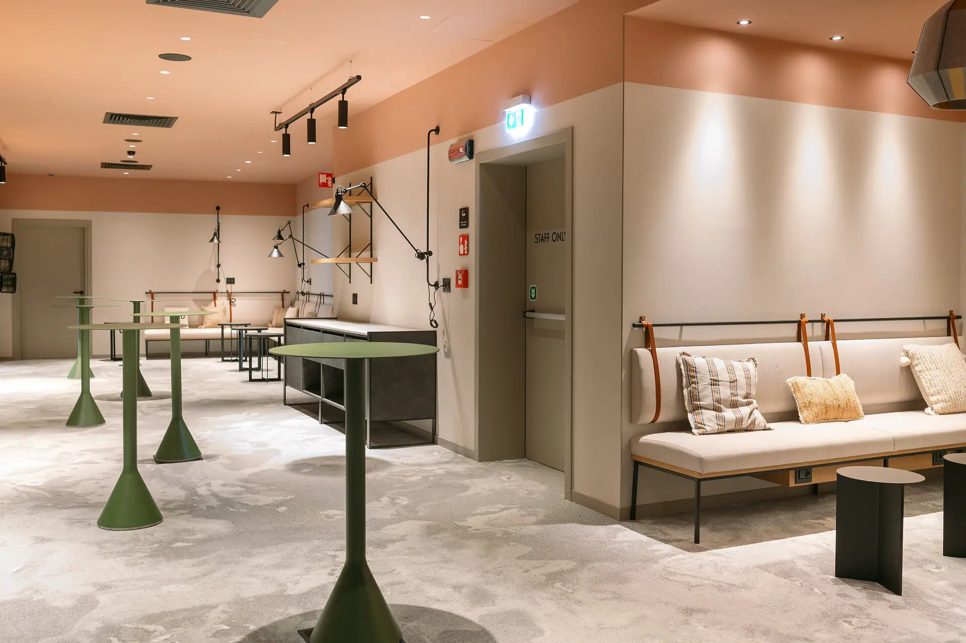 Foyer im A-ROSA Gardasee Ein Raum mit einer Couch und Tischen. Es gibt verschiedene Stehtische, die sich für einen Empfang eignen.