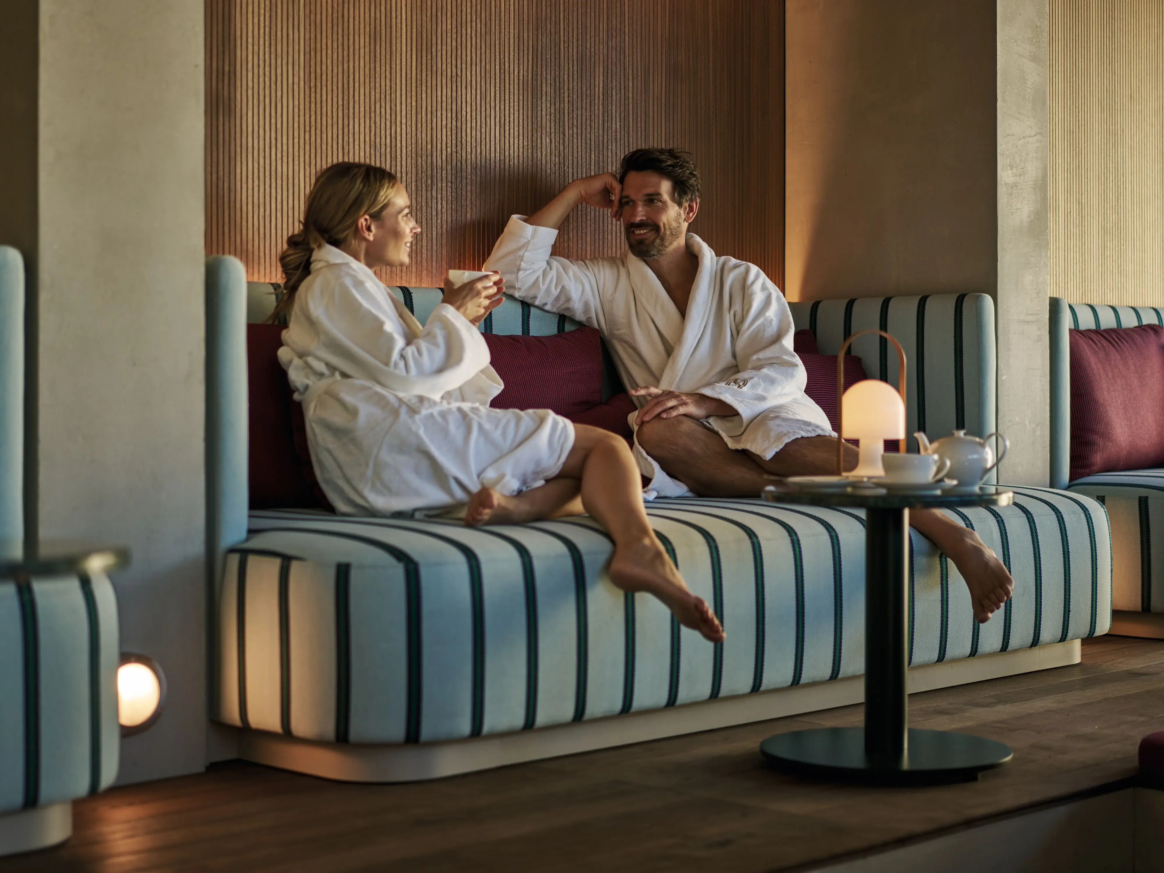 Couple in bathrobes relaxing in the lounge of Straubinger Grand Hotel Bad Gastein.