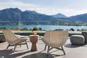 A table and chairs on a terrace overlooking a body of water.