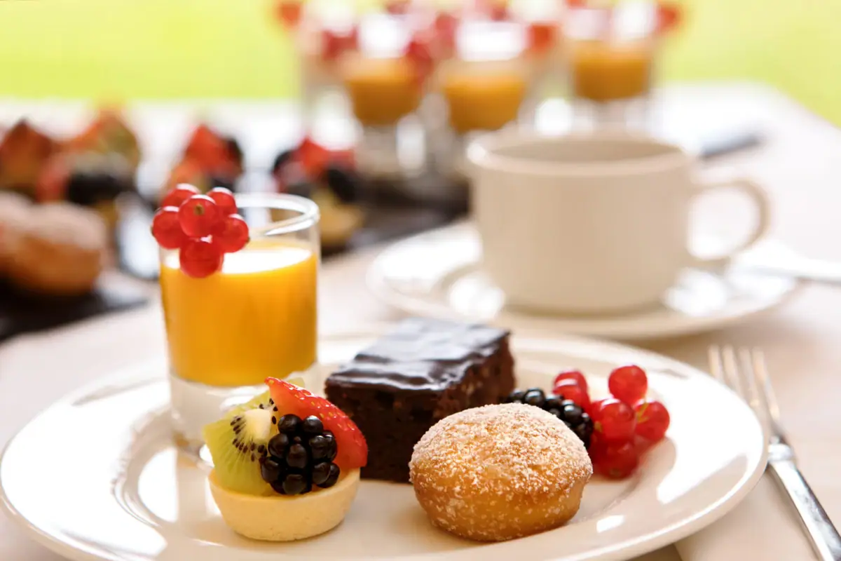 A plate of assorted desserts with a drink on the side.