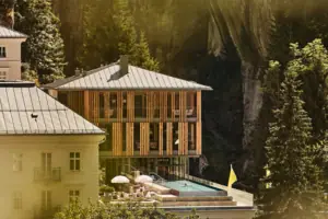 Gebäude mit Pool in der Mitte, umgeben von Bäumen und Pflanzen.