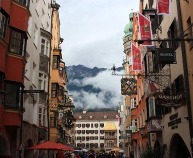 Between two groups of houses there is a shopping street with small cafes and restaurants which leads to a white house at the end