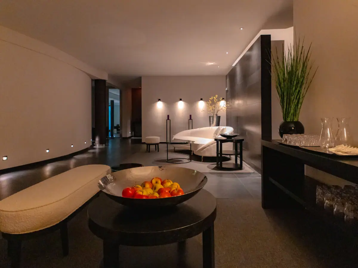 A bowl of fruit on a coffee table in a stylishly decorated room.