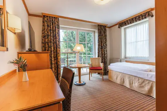 A hotel room with a bed, desk, and modern interior design.