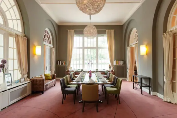 Ein Raum mit einem langen, eingedeckten Tisch und Stühlen.