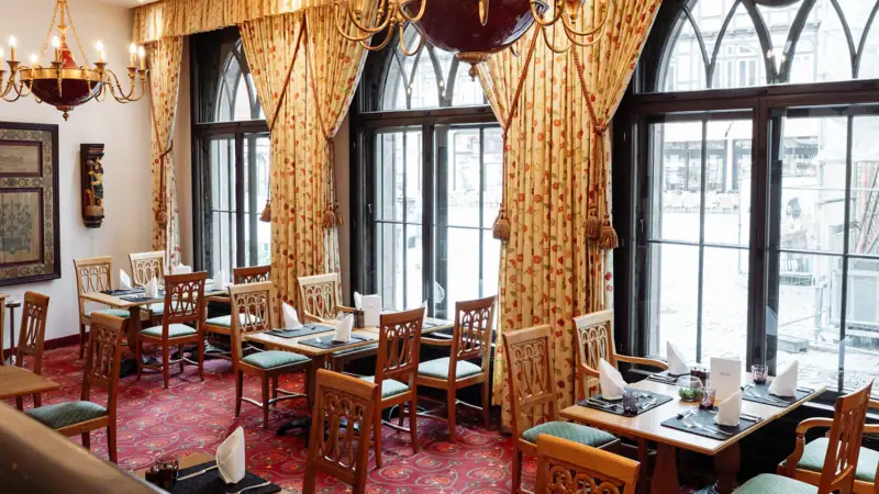A room with tables, chairs and a chandelier.