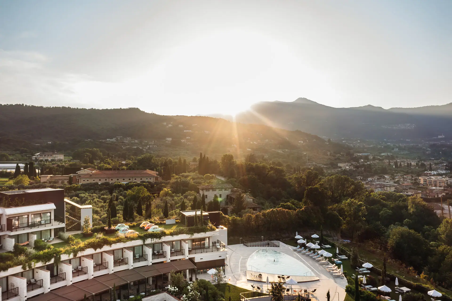 Sonne scheint über einem Resort im Freien mit Bergen im Hintergrund.