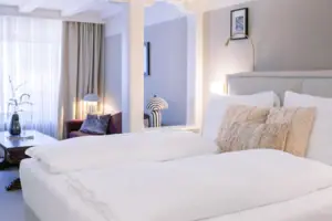 Bed with pillows and bed linen in a stylishly furnished room.
