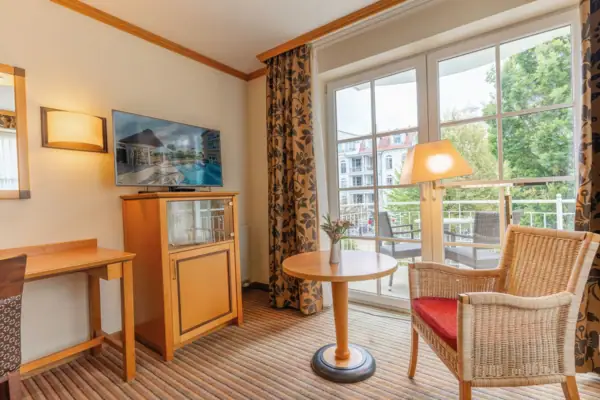 Room with a television and table, featuring modern interior design and wood flooring.