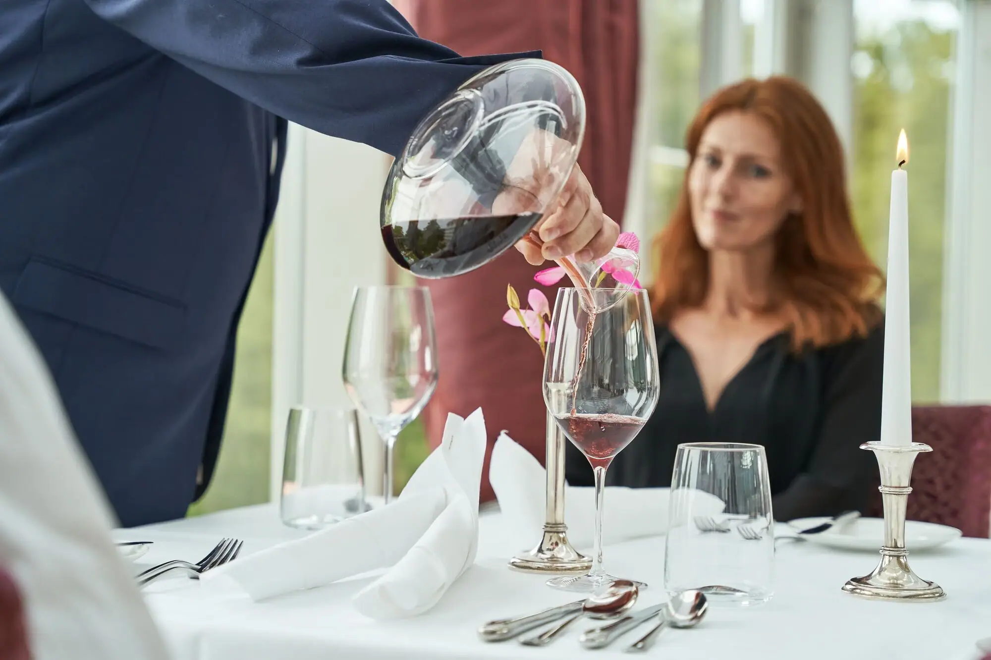 Eine Person schenkt Wein in ein Glas ein.