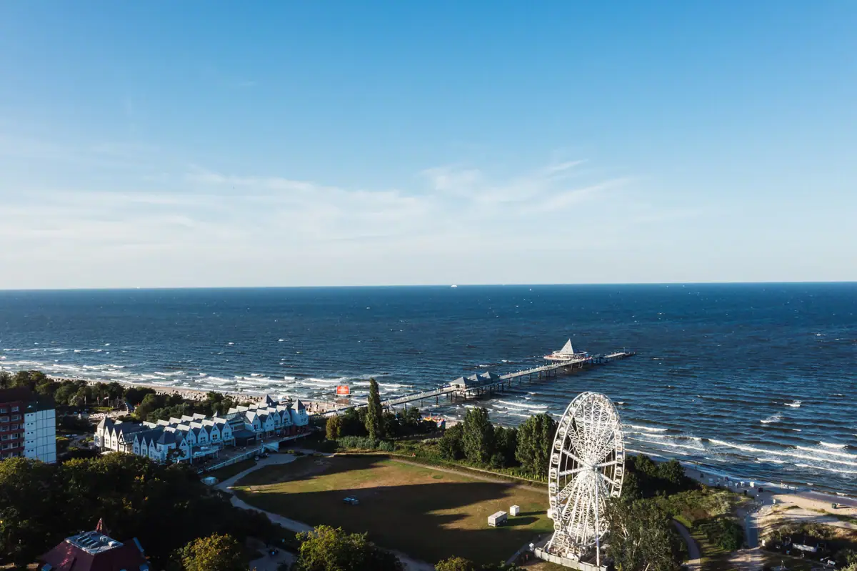 Großer Wasserkörper mit einem Riesenrad und einem Pier im Hintergrund.