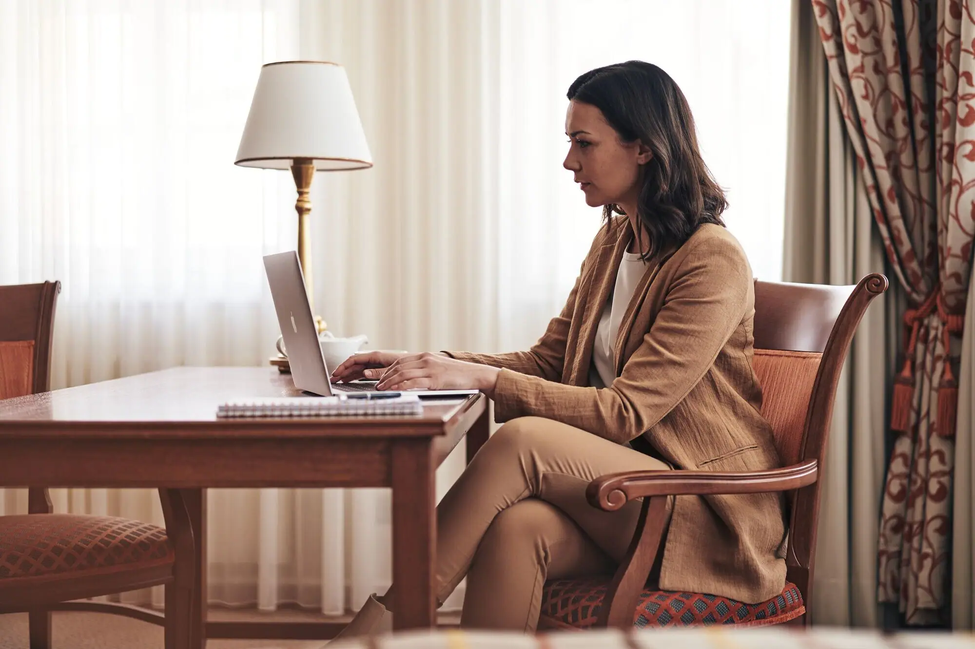 Frau am Laptop Frau sitzt an einem Schreibtisch und benutzt einen Laptop.