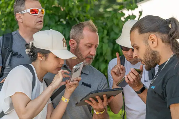 A group of people look at a tablet.