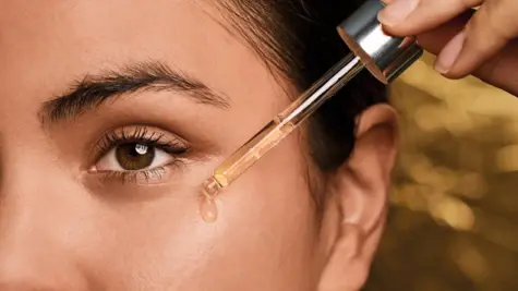 Woman puts drops in her eye with a pipette.