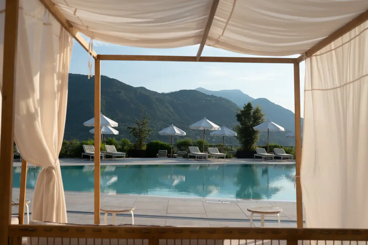 Pool with chairs and umbrellas under a clear sky.