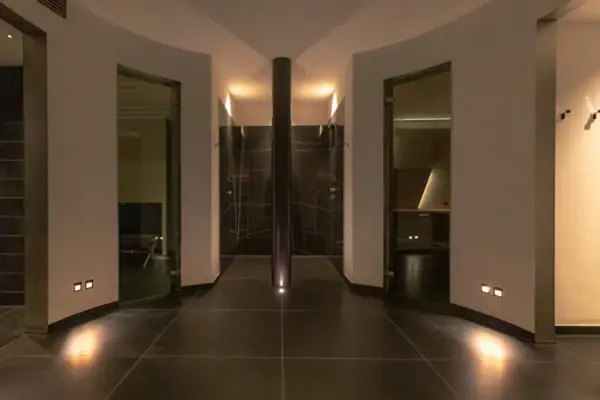 Room with a pillar and black tile floor.
