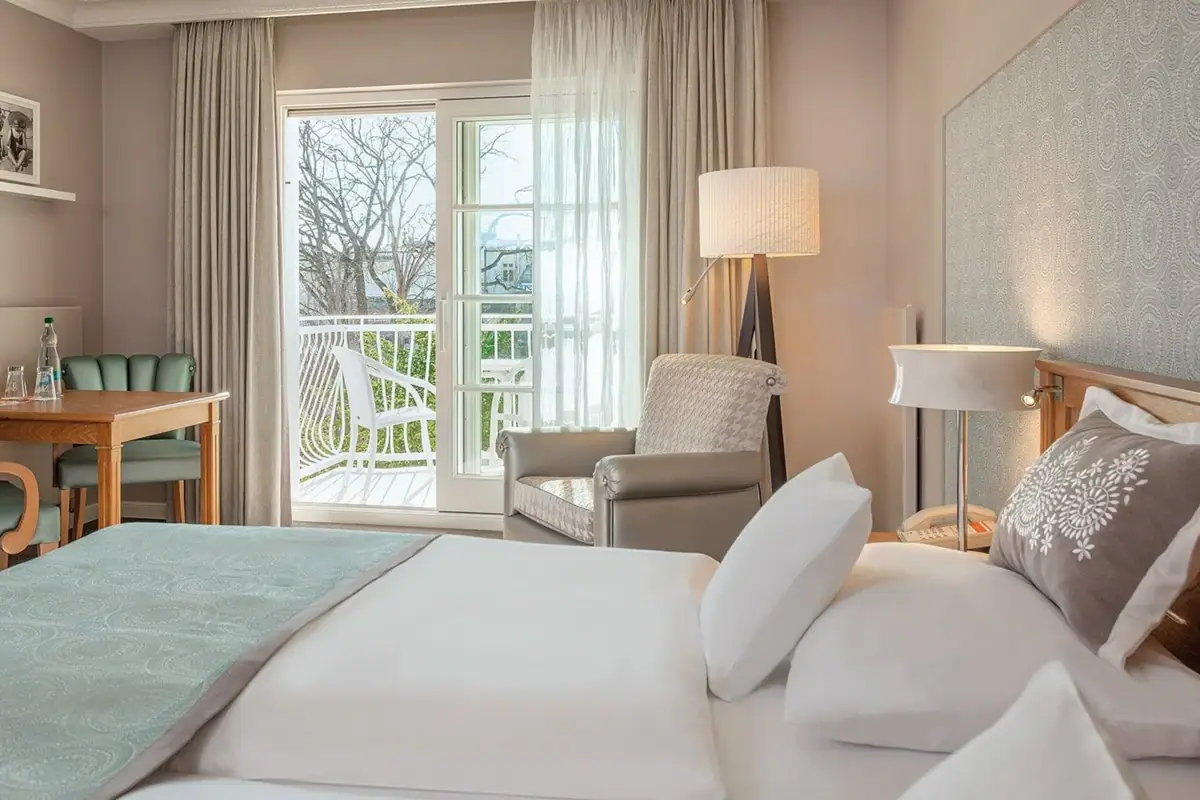 Rooms and Suites Hotel room with a large bed and a table.