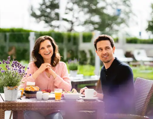 Ein Mann und eine Frau sitzen an einem Tisch mit Essen.